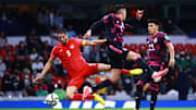 Jugadores de México pelean un balón.